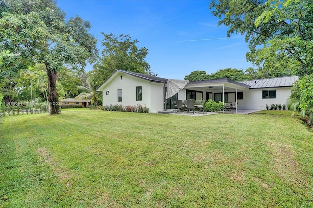 view of yard featuring ceiling fan and a patio