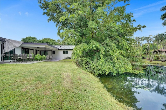 view of yard with a water view and a patio area