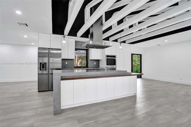 kitchen featuring stainless steel appliances, pendant lighting, white cabinets, and a kitchen island