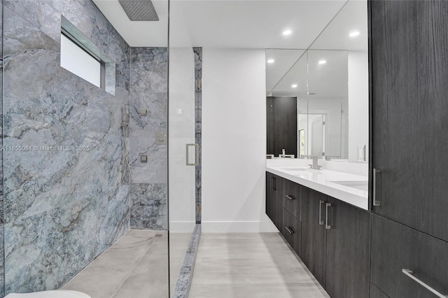 bathroom featuring a shower with door and vanity