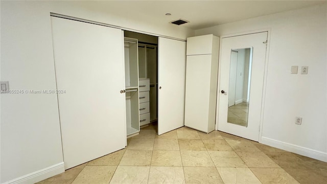 unfurnished bedroom featuring a closet and light tile patterned flooring