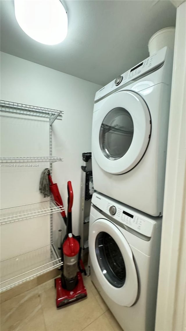 laundry area with stacked washer and dryer and light tile patterned flooring