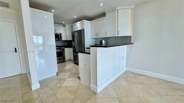 kitchen featuring tasteful backsplash, light tile patterned floors, stainless steel appliances, and white cabinetry