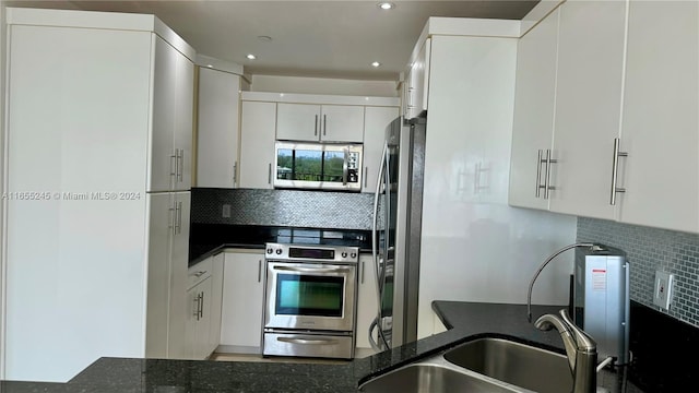 kitchen with appliances with stainless steel finishes, white cabinets, and decorative backsplash