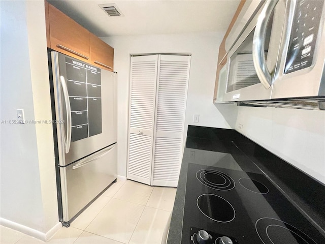 kitchen with stainless steel appliances and light tile patterned flooring