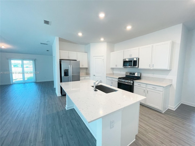 kitchen with light hardwood / wood-style flooring, stainless steel appliances, an island with sink, and sink