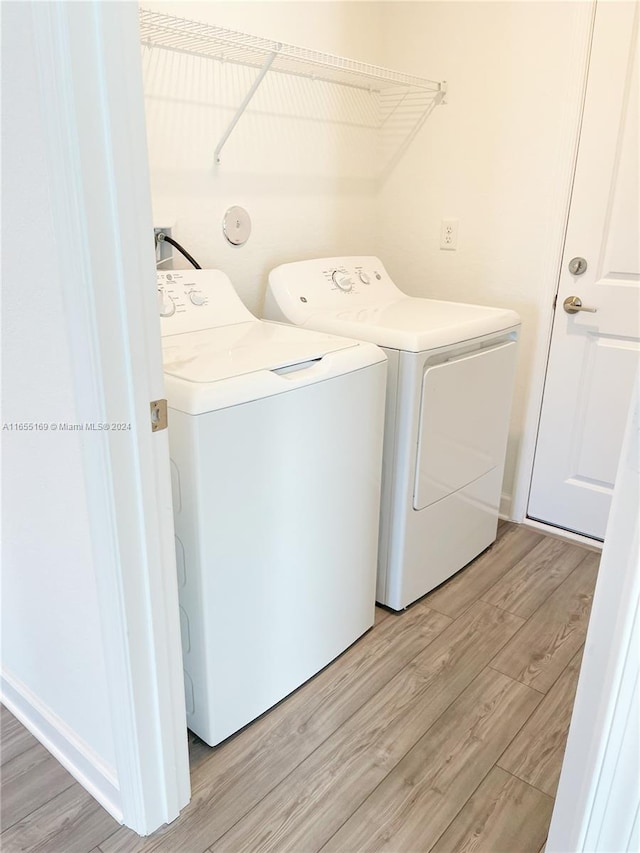 laundry area featuring washer and clothes dryer and light wood-type flooring