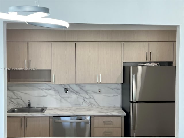 19380 Collins Ave Unit Ph-15, Sunny Isles Beach, FL 33160 - kitchen featuring appliances with stainless steel finishes, a sink, backsplash, light brown cabinets, and light stone countertops