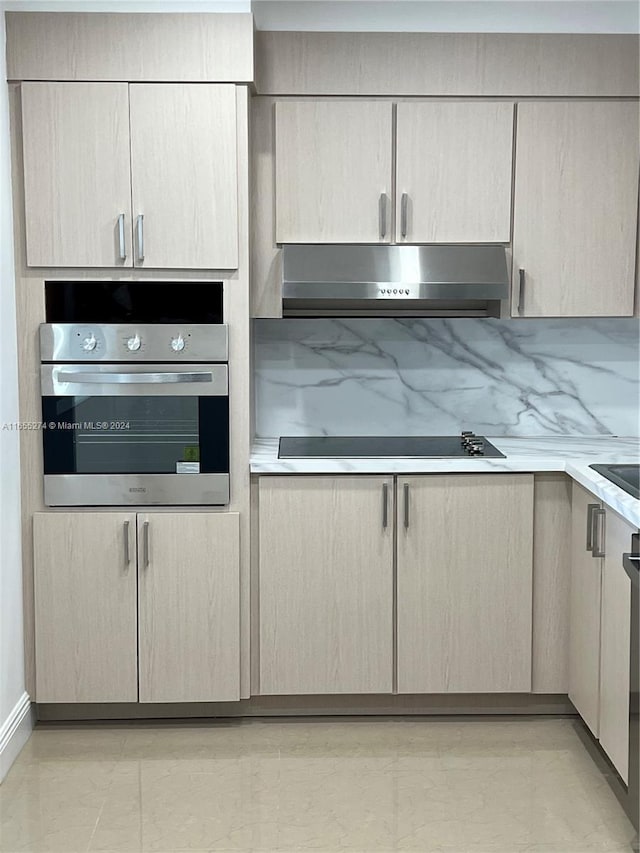 kitchen with stainless steel oven, ventilation hood, backsplash, black electric cooktop, and light tile patterned floors