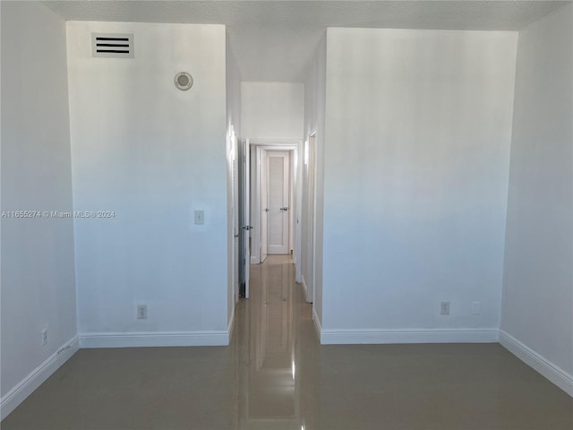 empty room featuring a textured ceiling and concrete floors