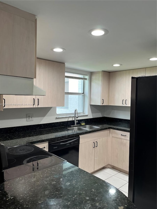 kitchen featuring dark stone countertops, sink, black appliances, light brown cabinets, and light tile patterned flooring