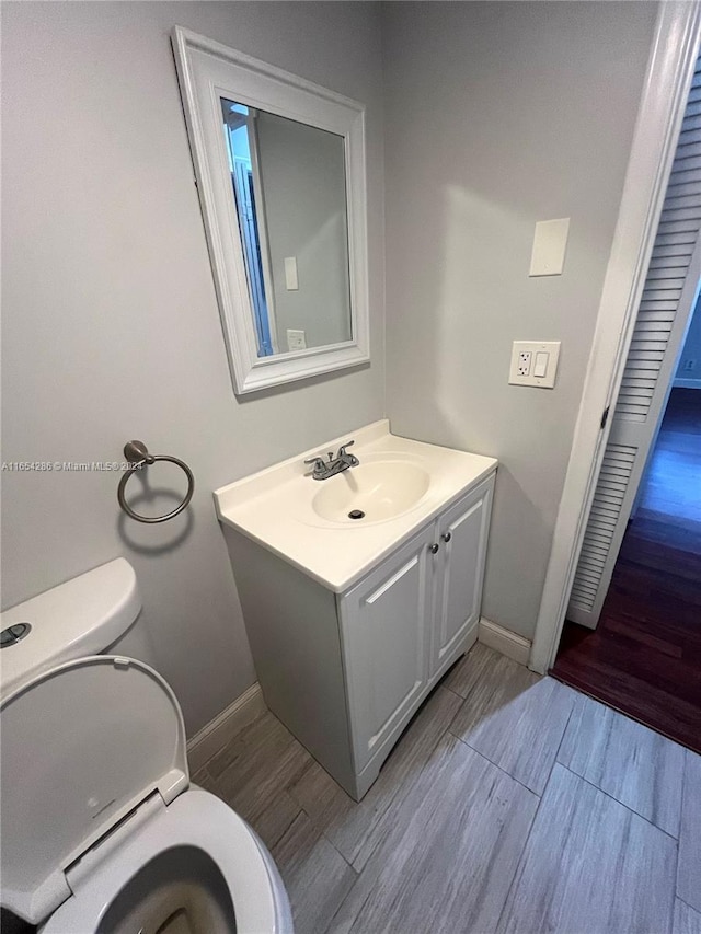 bathroom featuring vanity, toilet, and hardwood / wood-style flooring