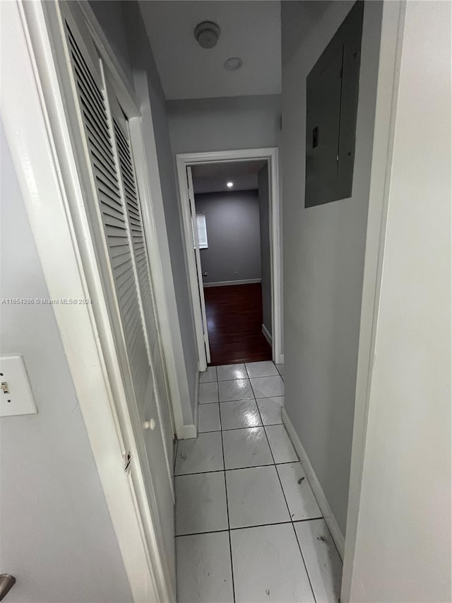 hallway with light tile patterned floors and electric panel