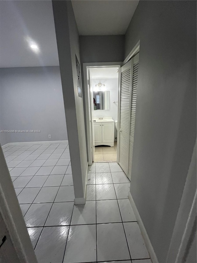 hall featuring light tile patterned floors and sink