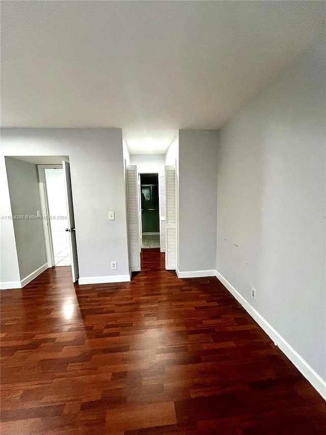 empty room with dark hardwood / wood-style flooring