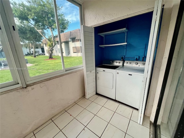 laundry area with light tile patterned floors and washer and clothes dryer