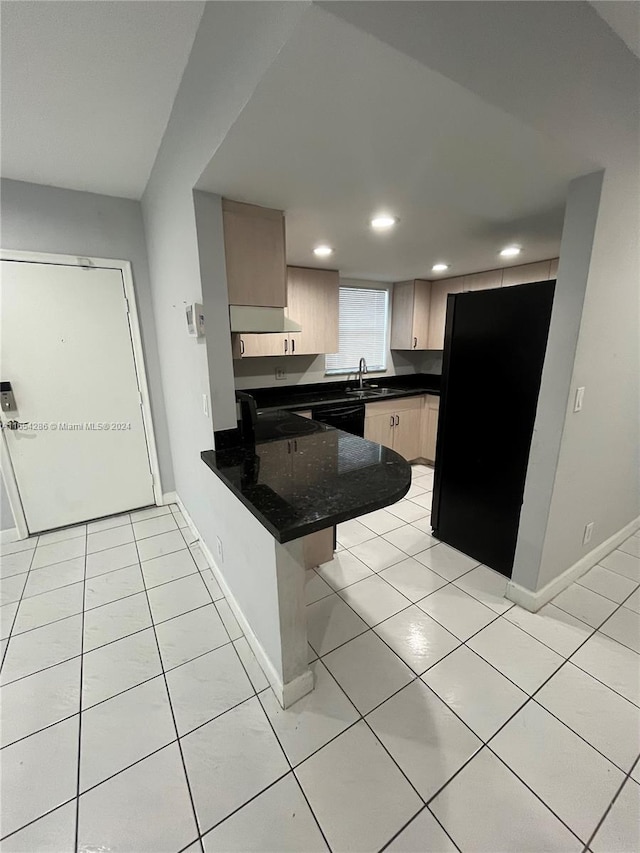 kitchen with kitchen peninsula, a kitchen bar, light tile patterned floors, and light brown cabinets