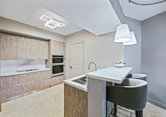 kitchen featuring stainless steel double oven, sink, black electric stovetop, a kitchen bar, and a center island with sink