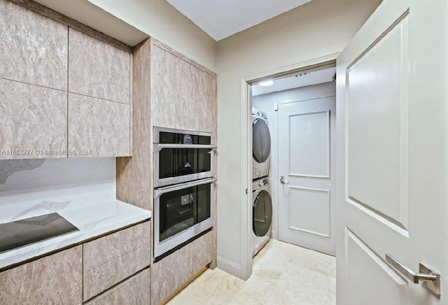 washroom with stacked washing maching and dryer