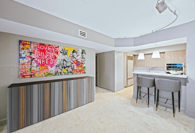 kitchen featuring pendant lighting, a breakfast bar, kitchen peninsula, and stainless steel oven