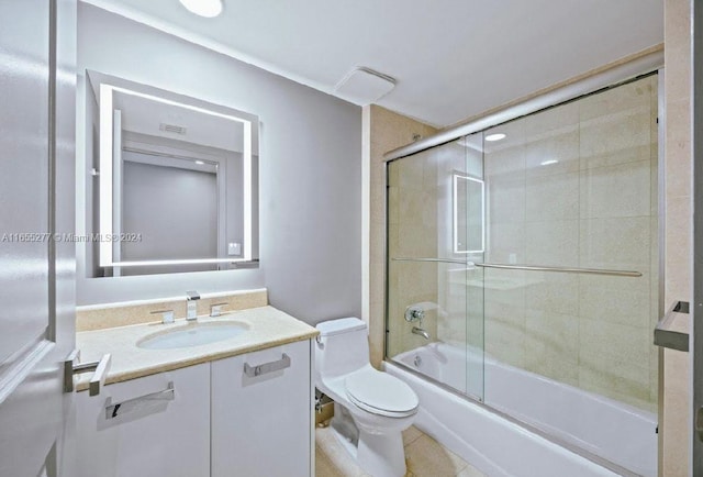 full bathroom featuring vanity, toilet, tile patterned floors, and bath / shower combo with glass door