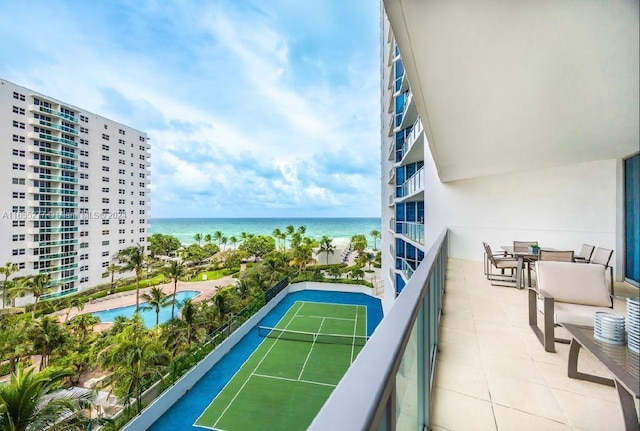 balcony featuring a water view and tennis court