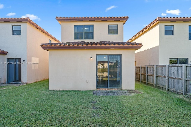 rear view of house featuring a lawn