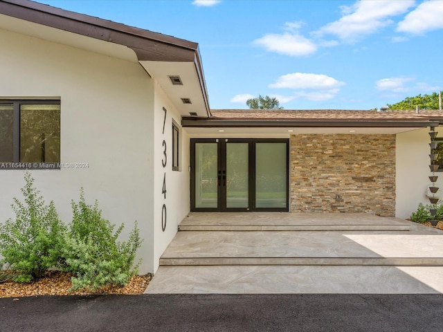 view of exterior entry with stucco siding and french doors