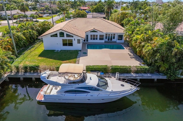 back of house with a lawn, a water view, and a patio