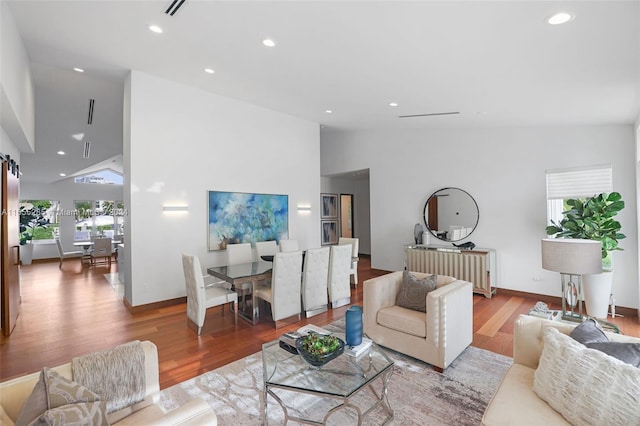 living room featuring light wood-type flooring and high vaulted ceiling