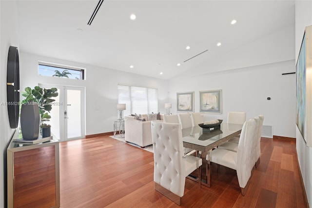 dining room featuring french doors, vaulted ceiling, and light wood-type flooring