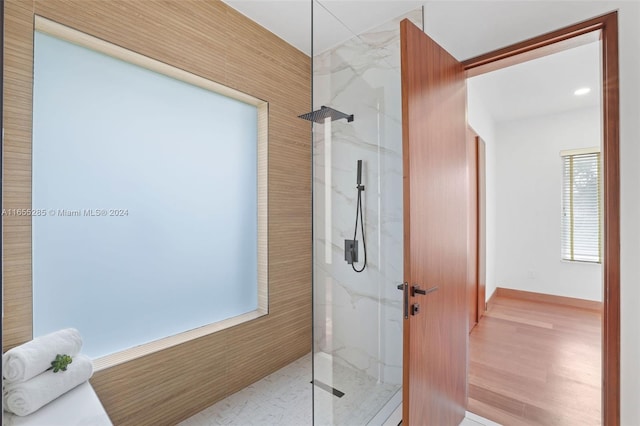 bathroom featuring wood-type flooring and tiled shower