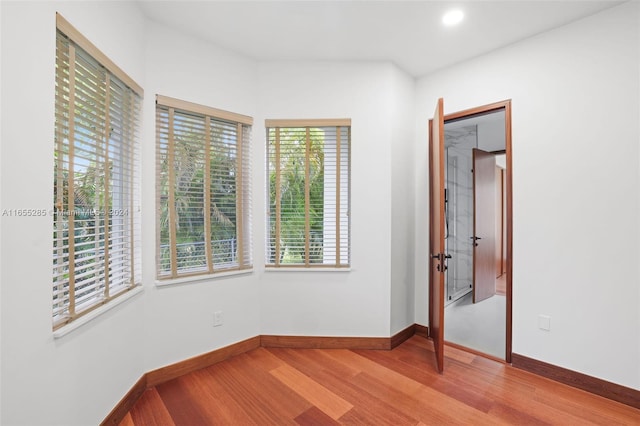 unfurnished room with plenty of natural light and hardwood / wood-style flooring