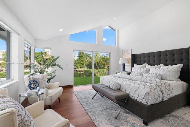 bedroom with multiple windows, dark hardwood / wood-style flooring, high vaulted ceiling, and access to exterior