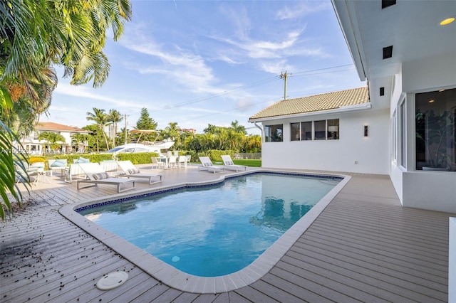 view of swimming pool featuring a patio area and a wooden deck