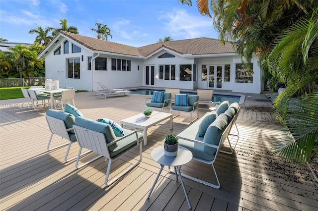 rear view of property with french doors, an outdoor hangout area, and a pool side deck