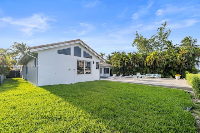 rear view of house featuring a patio area and a yard