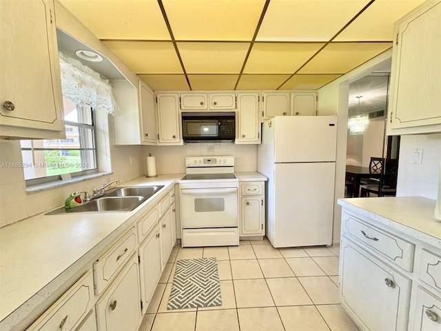 kitchen featuring white appliances, light tile patterned floors, tasteful backsplash, sink, and a drop ceiling