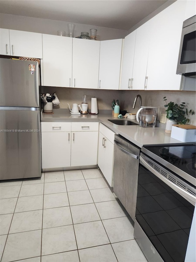 kitchen with stainless steel appliances, sink, and white cabinetry