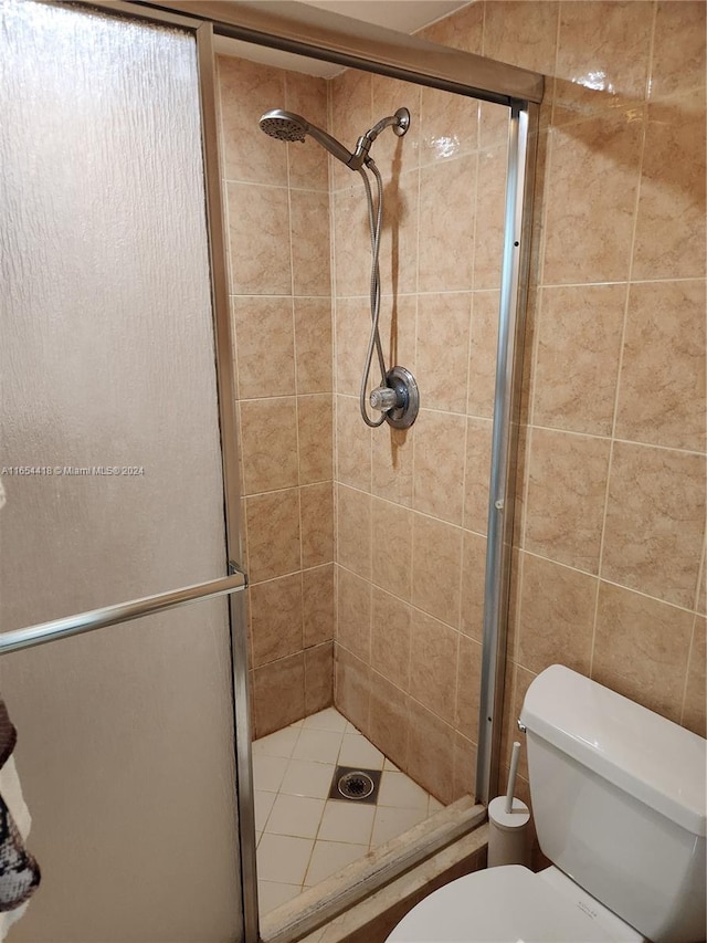 bathroom with an enclosed shower and toilet