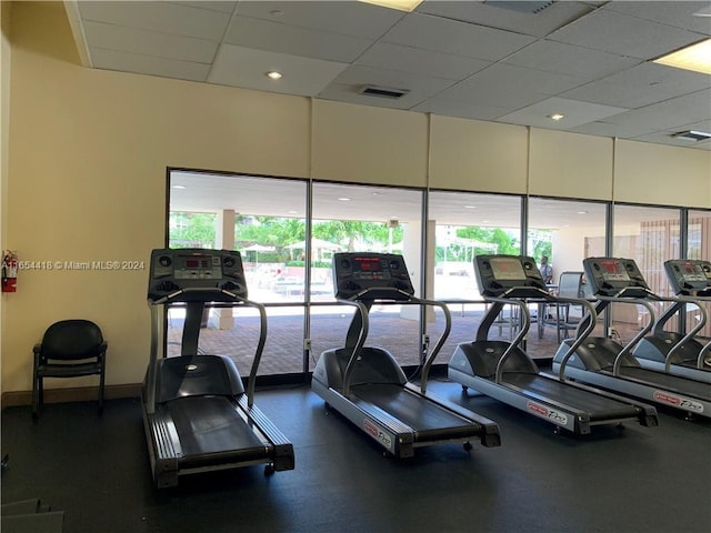 gym with a healthy amount of sunlight and a paneled ceiling