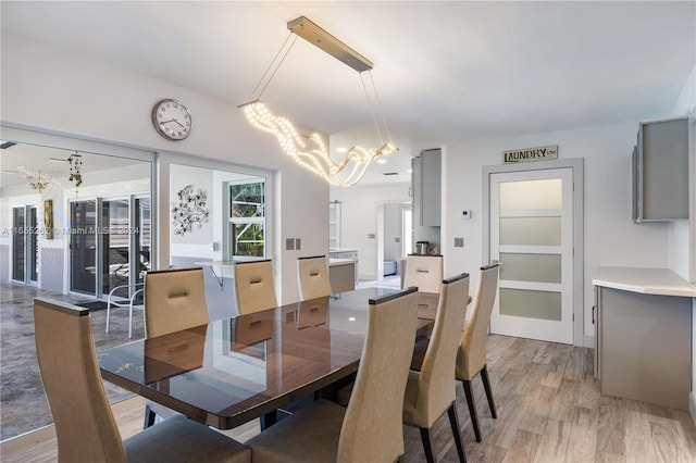 dining space with light hardwood / wood-style flooring and a chandelier