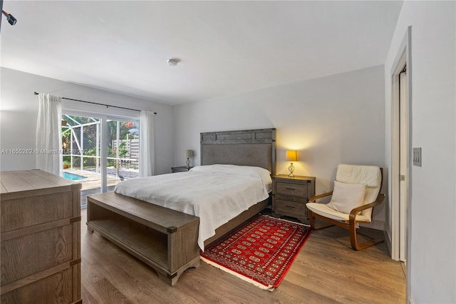 bedroom featuring wood-type flooring and access to outside