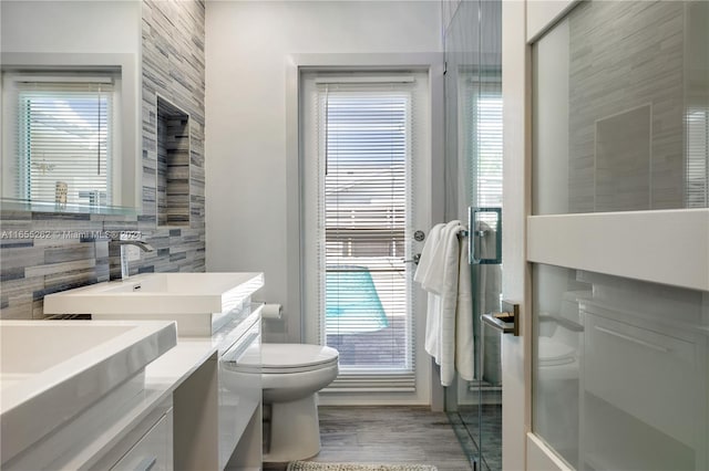 bathroom featuring hardwood / wood-style flooring, vanity, toilet, and an enclosed shower