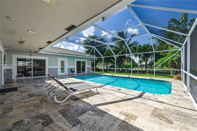 view of pool with glass enclosure and a patio area