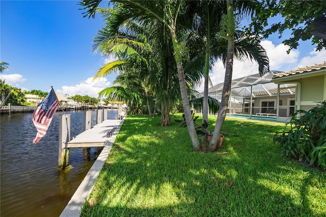 dock area featuring a lanai, a water view, and a lawn