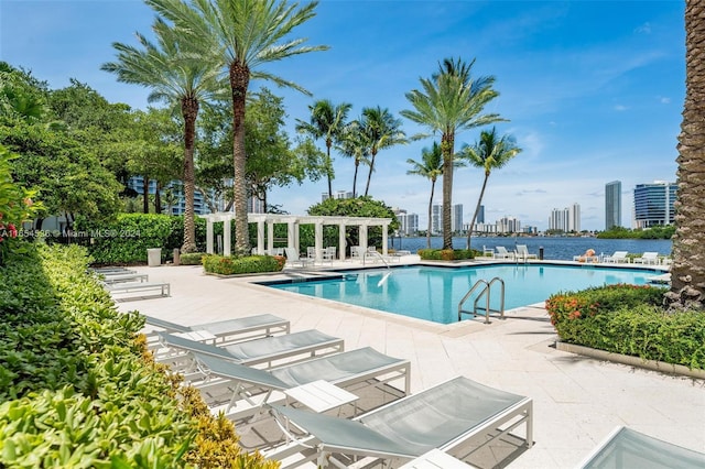 view of pool with a patio area and a water view