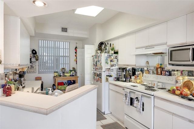 kitchen featuring kitchen peninsula, light tile patterned floors, white appliances, and white cabinetry