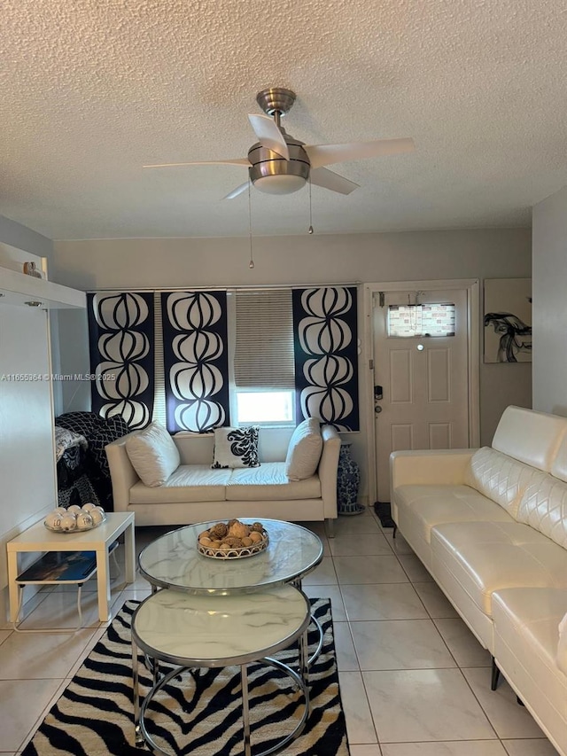 tiled living room featuring ceiling fan and a textured ceiling