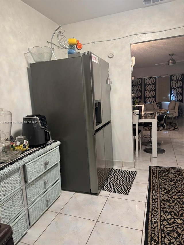 kitchen featuring light tile patterned flooring and stainless steel fridge with ice dispenser